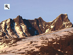 The Skagastls ridge from the west. From the left is Nordre Skagastlstind, Skagastlsnebbet, the notch of V-skaret, Midtre Skagastlstind, the step of Halls hammer, then Vetle Skagastlstind followed by Mohns skard saddle and Store Skagastlstind.
